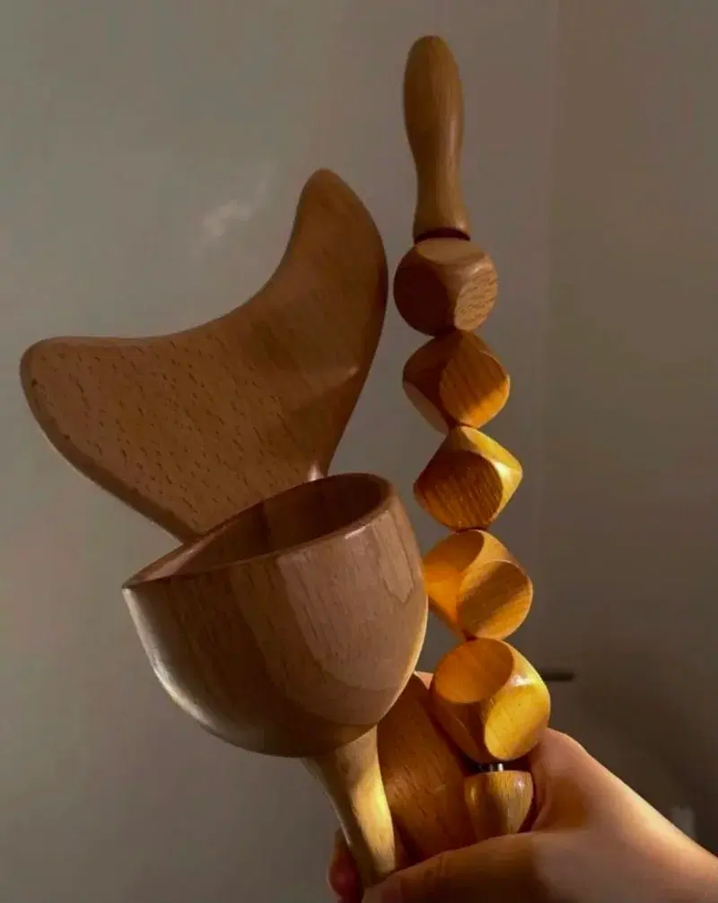 Outils de maderothérapie en bois tenus en main